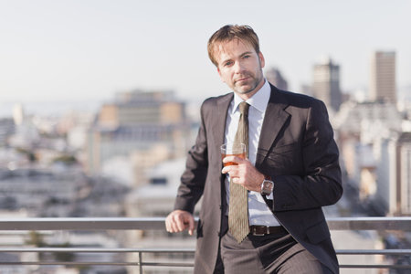 Businessman having a drink on rooftopの写真素材