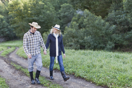 Smiling couple walking on dirt pathの写真素材