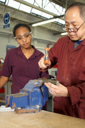 Worker using hammer in factory