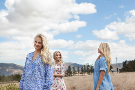Mother and daughters walking in fieldの写真素材