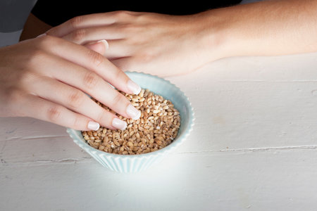 Woman touching bowl of grainsの写真素材