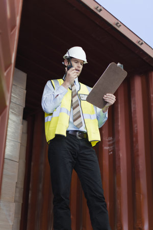 Worker using walkie talkie in container