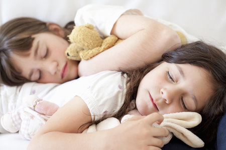 Girls napping on couch togetherの写真素材