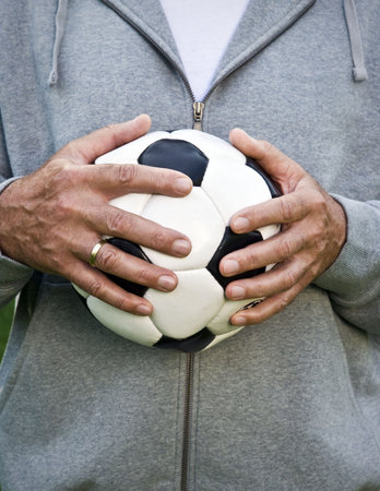 Mans hands holding footballの写真素材