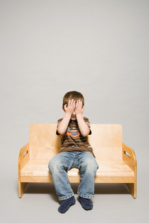 A boy covering his eyesの写真素材