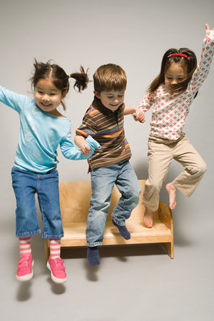 Children jumping off a benchの写真素材