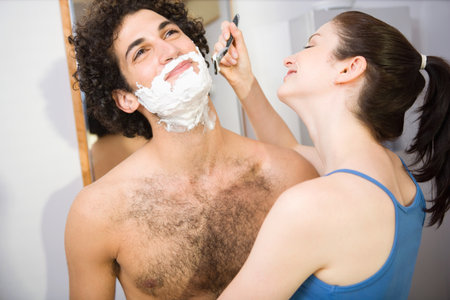 Woman helping a man shaveの写真素材