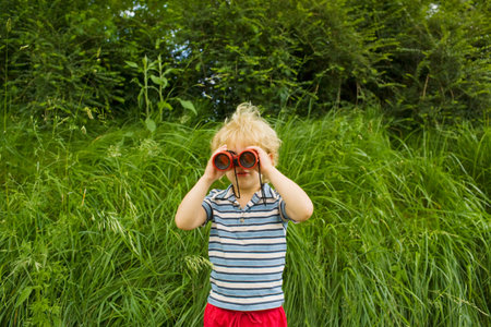 A boy looking through binocularsの写真素材