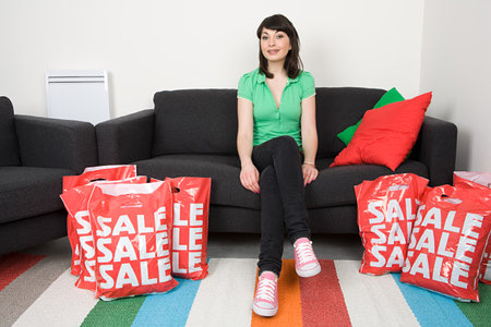Woman sitting with shopping bagsの写真素材