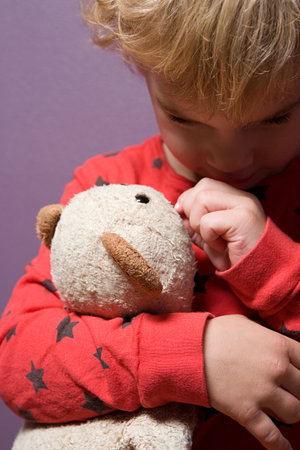 Boy hugging a teddy bearの写真素材