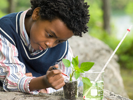 A boy doing an experiment on a plantの写真素材