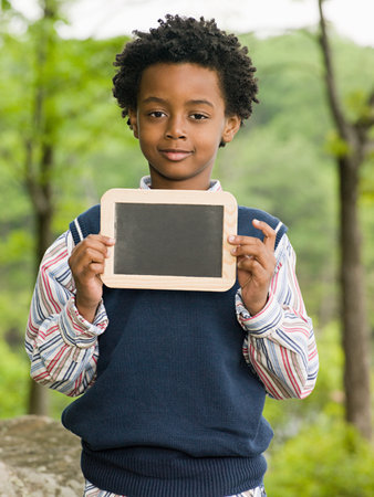 A boy holding a blackboardの写真素材