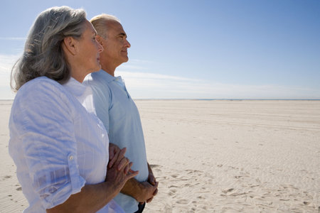 Senior couple walking on beachの写真素材