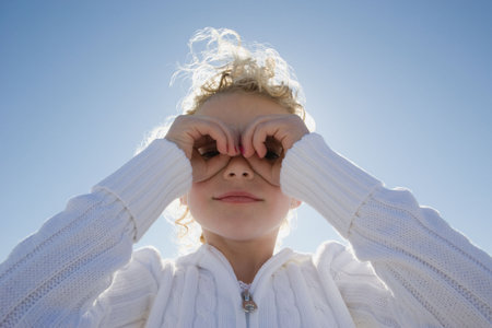 Girl looking through handsの写真素材