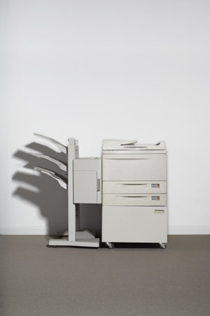 A photocopier against a white wall.の写真素材