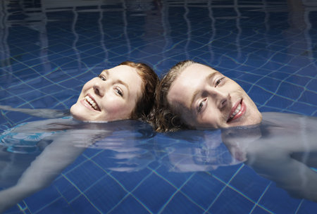 Man and woman floating in a poolの写真素材