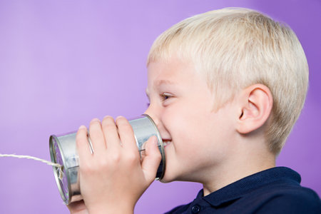 Boy talking on a tin can telephoneの写真素材
