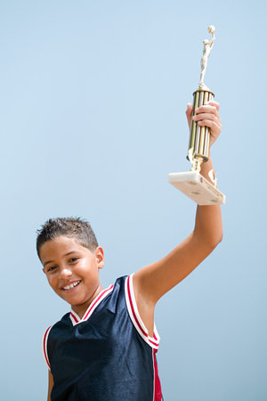 Boy holding up basketball trophyの写真素材