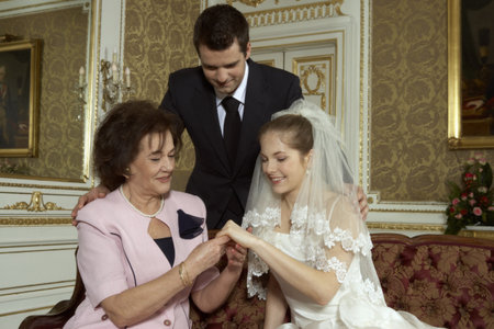 Bride, Groom and brides Mother looking at wedding ringの写真素材