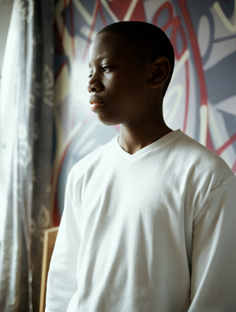 Teenage boy standing in bedroomの写真素材