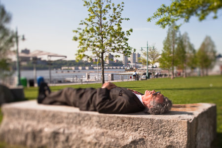 Senior man lying on a stone block in park