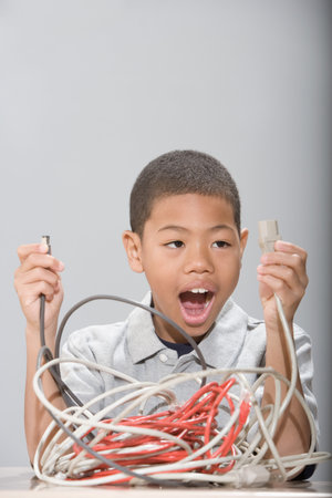 Boy with tangled cablesの写真素材