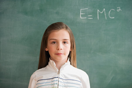 Girl standing at blackboardの写真素材