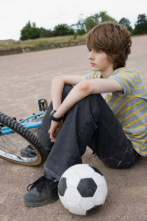 Teenager with bike and footballの写真素材