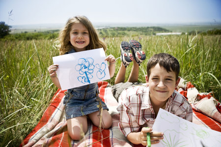 Two children showing their drawingsの写真素材