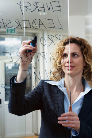 Businesswoman writing keywords on glassの写真素材