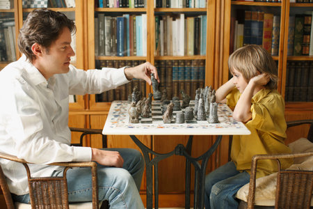 Father playing chess with young boyの写真素材
