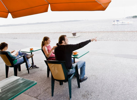 Man and women sitting at a cafeの写真素材