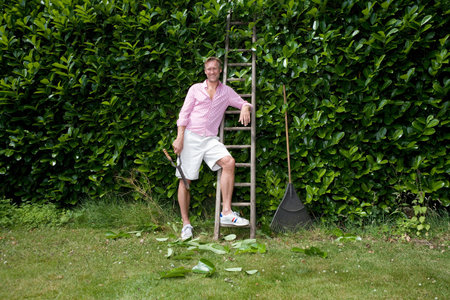 Portrait of man with secateurs by ladderの写真素材