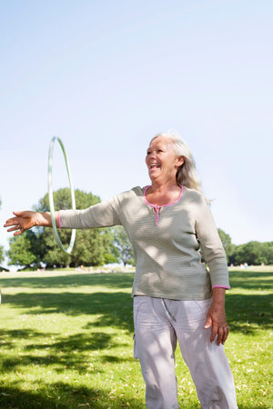 Mature woman with hula-hoopの写真素材