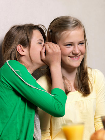 Girl whispering in friends earの写真素材