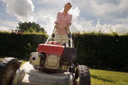 Man with push lawnmower, low angleの写真素材