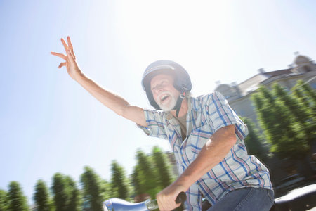 Man on scooter, wavingの写真素材