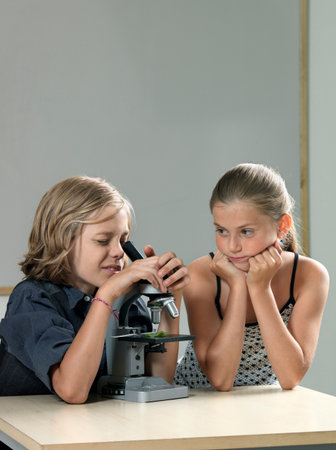 Two kids using microscopeの写真素材