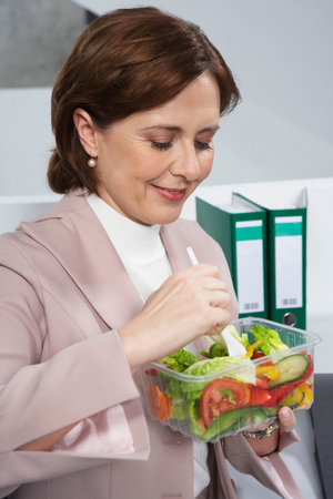 Business woman eating saladの写真素材