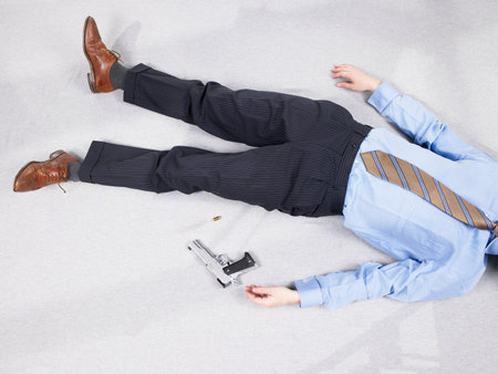 Man lying on floor with gunの写真素材