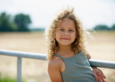 Young girl on farm gateの写真素材