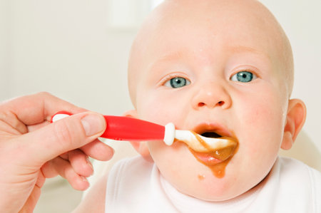 A portrait of a baby eating his food.の写真素材