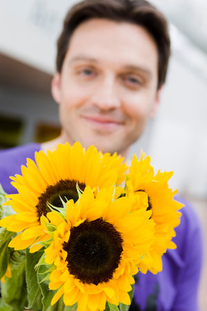 Man giving flowers to the viewerの写真素材