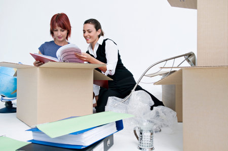 Business colleagues unpack office boxesの写真素材