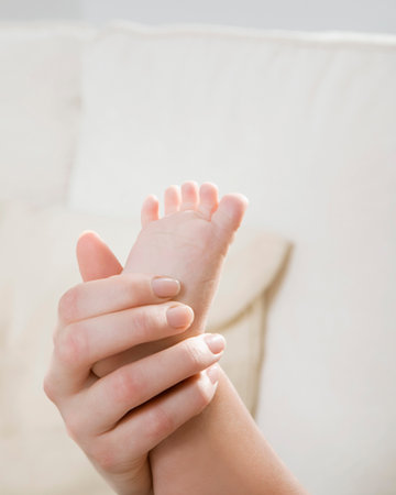 A mother holding her child's foot.の写真素材