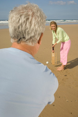 Couple playing cricket on a beachの写真素材