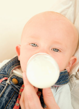A baby relaxed drinking a bottle of milkの写真素材