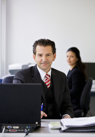 Portrait of workers in busy officeの写真素材