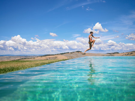 Woman jumping in swimming poolの写真素材