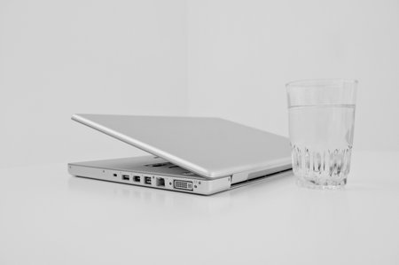 A laptop and a glass of water.